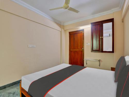 a bedroom with a bed and a ceiling fan at Family Castle Hotel in Trivandrum