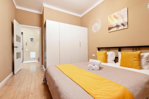 a bedroom with a large bed with yellow sheets at Абрикосовое парфе in Astana