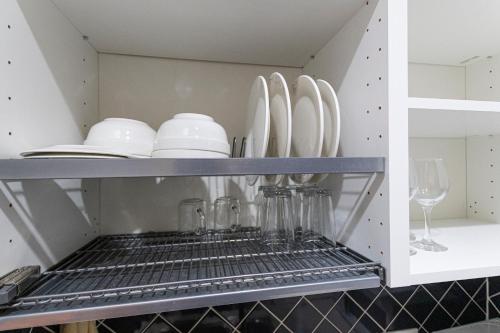 a shelf with plates and glasses and a wine glass at Абрикосовое парфе in Astana