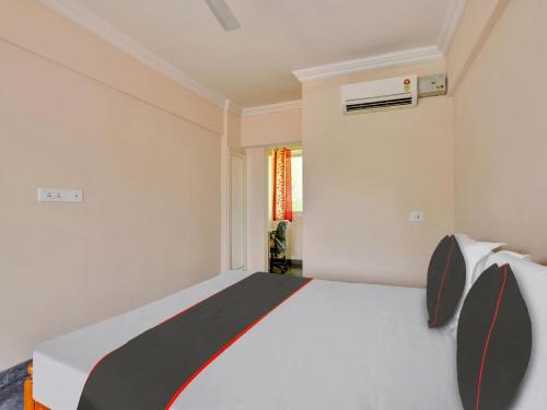 a bedroom with a white and black bed and a window at Family Castle Hotel in Trivandrum