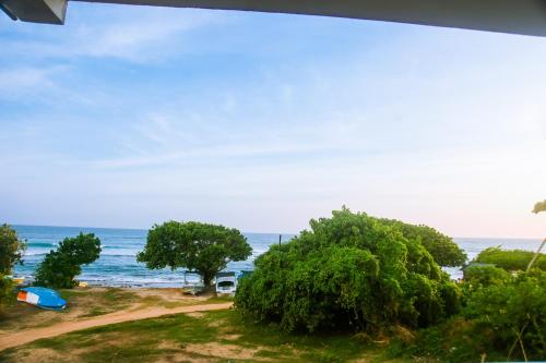 a view of a beach with trees and the ocean at Mirissa Turtle Point Guest in Mirissa