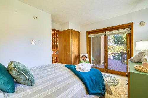 a bedroom with a bed with blue sheets and a balcony at Walk to Beach Arrowhead Lake Home in Pocono Lake
