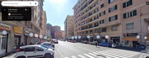 Una calle de la ciudad con coches aparcados en la calle. en Titti's House - Parcheggio custodito in garage gratis, en Génova