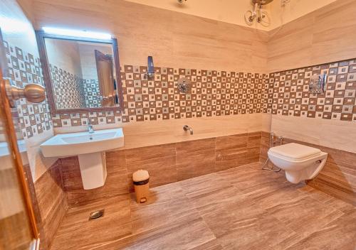 a bathroom with a sink and a toilet at Ushasree Wayanad Pool Resort by VOYE HOMES in Ambalavayal