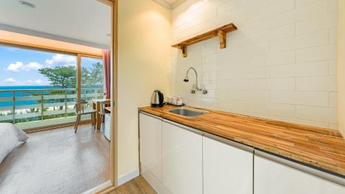 a kitchen with a sink and a view of the ocean at Gangneng badapunggeong Pension in Gangneung