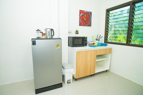 a kitchen with a refrigerator and a counter with a microwave at Songbird Suites - Deluxe 2 Bedroom, 2 Bathroom Apt in Ban Khlong Haeng