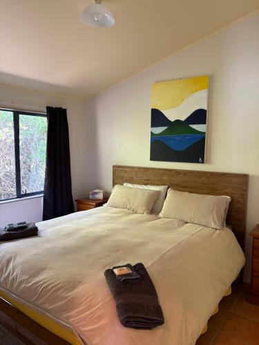 a bedroom with a large bed with a blanket on it at Dawson Downs in Upper Moutere