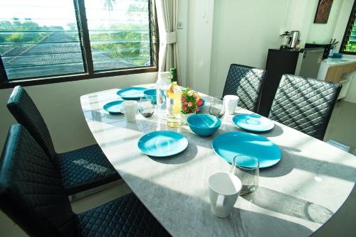 a dining room table with blue dishes on it at Songbird Suites - Deluxe 2 Bedroom, 2 Bathroom Apt in Ban Khlong Haeng