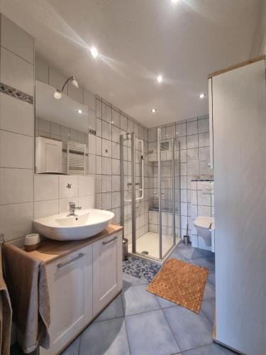a bathroom with a sink and a shower and a tub at Ferienwohnung Nähe Berlin in Fredersdorf