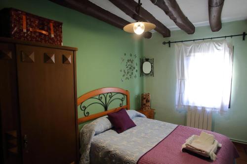 a bedroom with a bed and a window at Casa Rural La Tejada in Alcalá de Moncayo