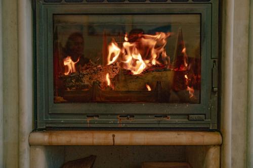 a fireplace with fire in it in a room at CrosswayBg Pamporovo in Pamporovo