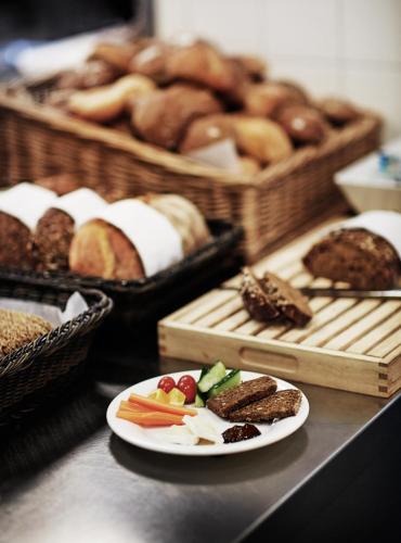 una mesa con un plato de comida y cestas de pan en Europahuset Apartments, en Copenhague