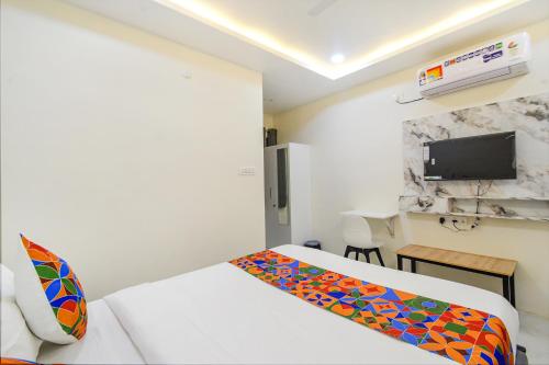a hotel room with a bed and a tv at FabHotel SSR Ikon Suites - Nr Hyderabad Central University, Kondapur in Hyderabad