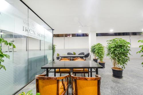 a table and chairs in a room with plants at FabHotel SSR Ikon Suites - Nr Hyderabad Central University, Kondapur in Hyderabad