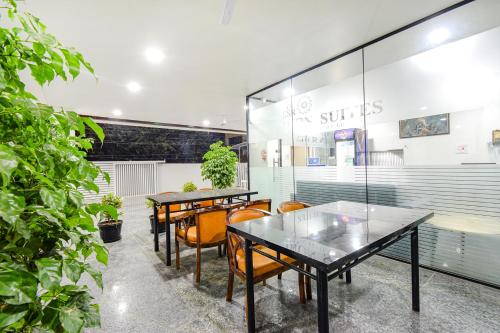 a group of tables and chairs in a restaurant at FabHotel SSR Ikon Suites - Nr Hyderabad Central University, Kondapur in Hyderabad