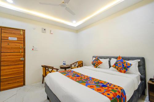a bedroom with two beds and a wooden door at FabHotel SSR Ikon Suites - Nr Hyderabad Central University, Kondapur in Hyderabad