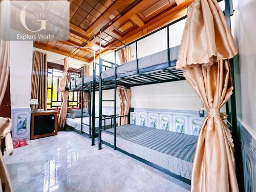 a bedroom with two bunk beds and a tv at The Ridge Haven in Phong Nha