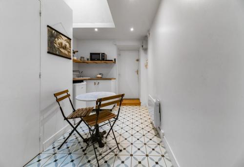 une petite cuisine avec une table et des chaises dans une pièce dans l'établissement Le Paradis - Appartement cœur de ville, à Clermont-Ferrand