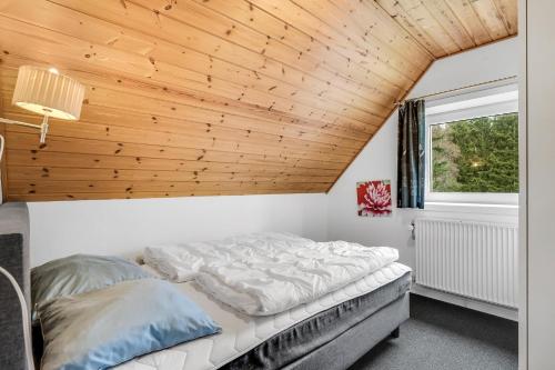 a bed in a room with a wooden ceiling at Large Pool House For 20 People, Where Hunting Is Allowed In The Adjacent Forest in Brande