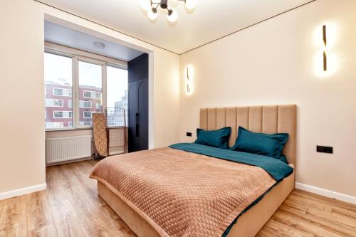 Un dormitorio con una cama grande con almohadas azules. en Oasis апартаменты возле Хан-Шатыра, en Astana