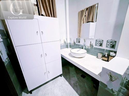 a white bathroom with a sink and a mirror at The Hill Villas in Phong Nha