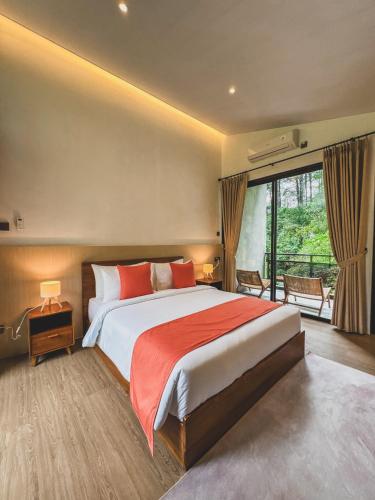a bedroom with a large bed and a large window at Arunika Villa in Ciloto
