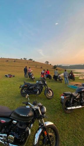 a group of motorcycles parked in a field at Homie Hub in Meppādi