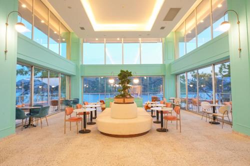a dining room with tables and chairs and windows at Orka Lotus Beach in Marmaris