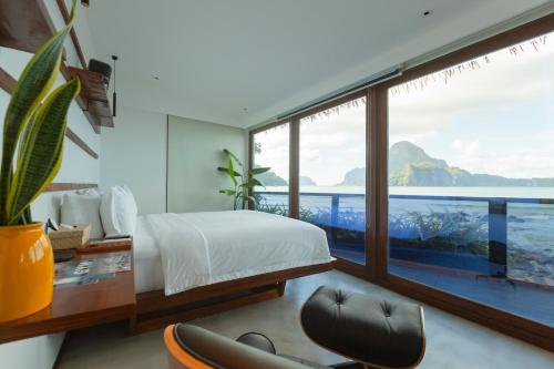 a bedroom with a view of the ocean at Morgan Villas in El Nido