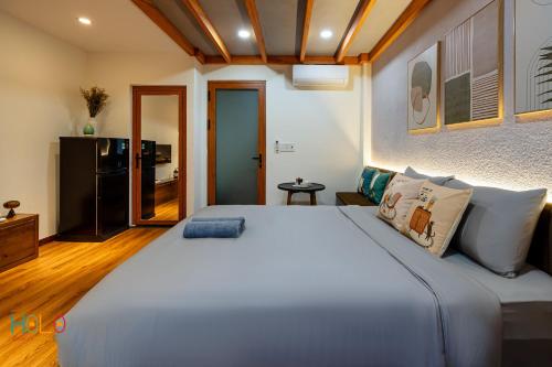 a bedroom with a large white bed and a kitchen at HOLO HAM NGHI SAIGON - Serviced HomeStay in Ho Chi Minh City