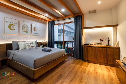 a bedroom with a large bed and a window at HOLO HAM NGHI SAIGON - Serviced HomeStay in Ho Chi Minh City