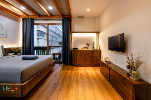 a bedroom with a bed and a flat screen tv at HOLO HAM NGHI SAIGON - Serviced HomeStay in Ho Chi Minh City
