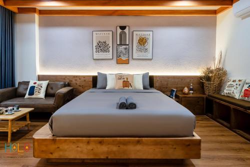 a bedroom with a large bed and a couch at HOLO HAM NGHI SAIGON - Serviced HomeStay in Ho Chi Minh City