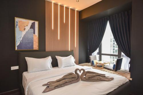 a bedroom with two swans towels on a bed at R&F Princess Cove by Nest Home at Johor Bahru in Johor Bahru