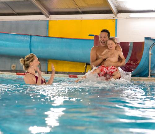 a man and a woman and a child in a swimming pool at St. Ives Holiday Village in St Ives