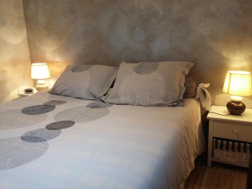 a bedroom with a white bed with two lamps at Les Mystères D'Omaha Beach in Surrain