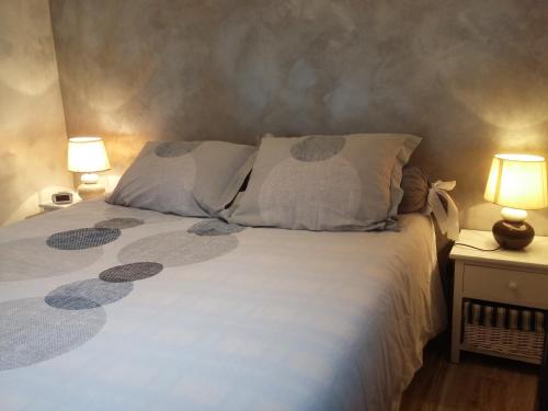 sypialnia z białym łóżkiem z 2 lampami w obiekcie Les Mystères D'Omaha Beach w mieście Surrain