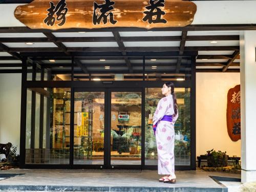 a woman in kimono standing in front of a store at Kirishima Momijidani Seiryuso in Kirishima