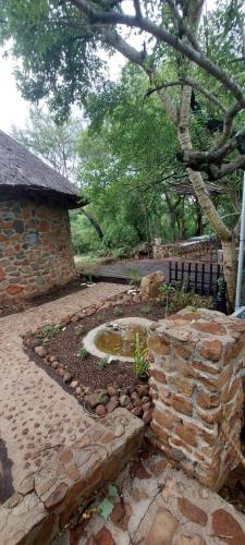 a stone wall with a fountain in a garden at Uitpak in Barberton