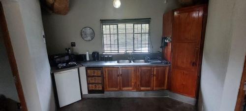 a small kitchen with a sink and a window at Uitpak in Barberton