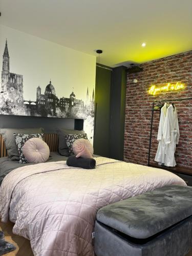 une chambre avec un grand lit et un mur de briques dans l'établissement Appartement fabuleux 100 m2 parking privatif entièrement climatisé, à Bischheim