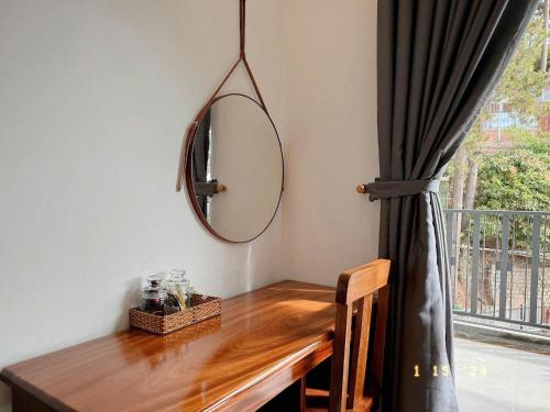 a mirror on a wall next to a table at Sunflower Garden Homestay Đà Lạt in Xuan An