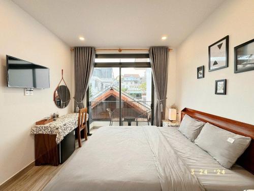 a bedroom with a bed and a desk and a window at Sunflower Garden Homestay Đà Lạt in Xuan An