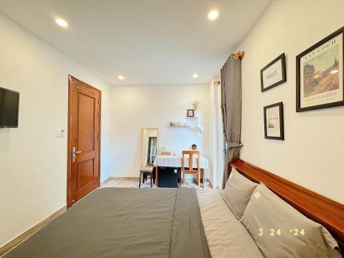 a bedroom with a bed and a table in a room at Sunflower Garden Homestay Đà Lạt in Xuan An