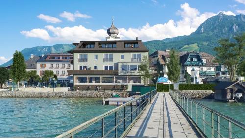 a bridge over a body of water with a building at Seehotel Lilly in Strobl