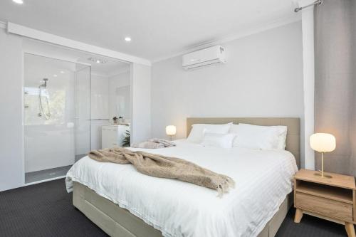 a bedroom with a white bed with a blanket on it at Riverside Bliss - Luxe Retreat in South Yunderup - Pet friendly in South Yunderup