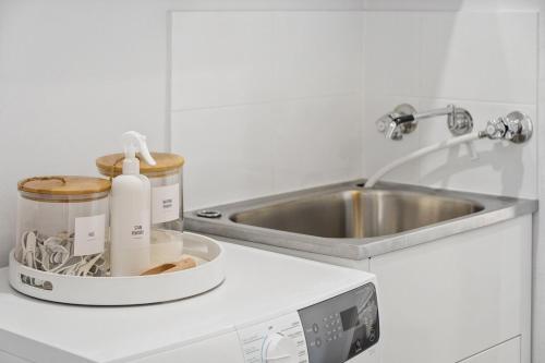 a white kitchen with a sink and a counter top at Riverside Bliss - Luxe Retreat in South Yunderup - Pet friendly in South Yunderup