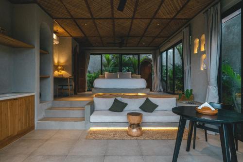 a bedroom with a bed and a couch and a table at SIVANA, Hotel Boutique with ocean or garden views - Adults only in Uluwatu