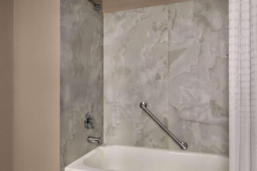 a bathroom with a white tub and a shower curtain at Days Inn by Wyndham Memphis at Graceland in Memphis