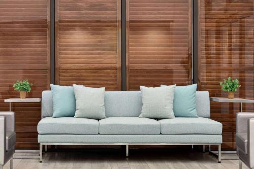 a blue couch in a room with wooden walls at Wingate by Wyndham Green Bay in Green Bay